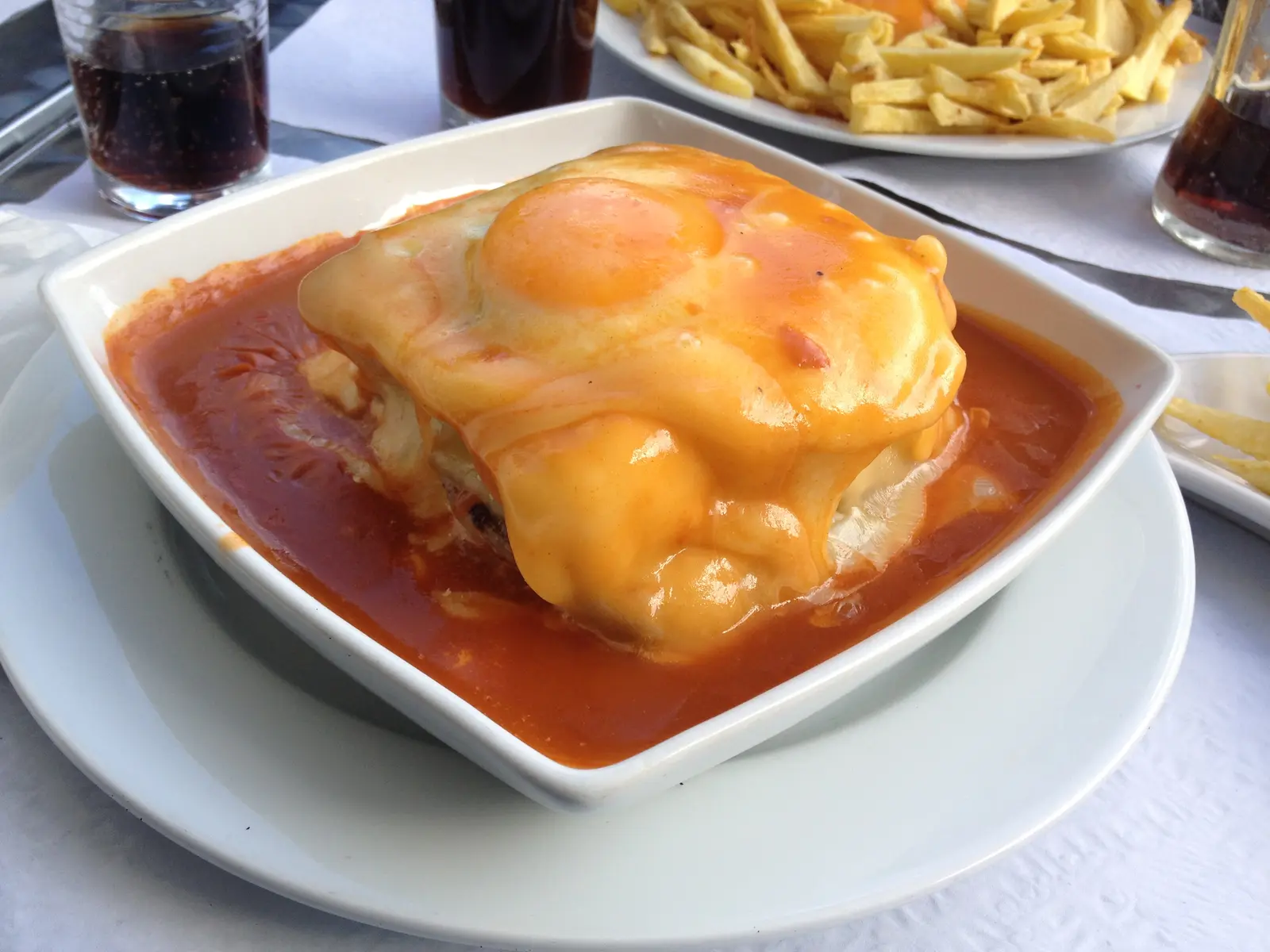 A francesinha especial in Porto with melted cheese, sauce, fried egg and fries.