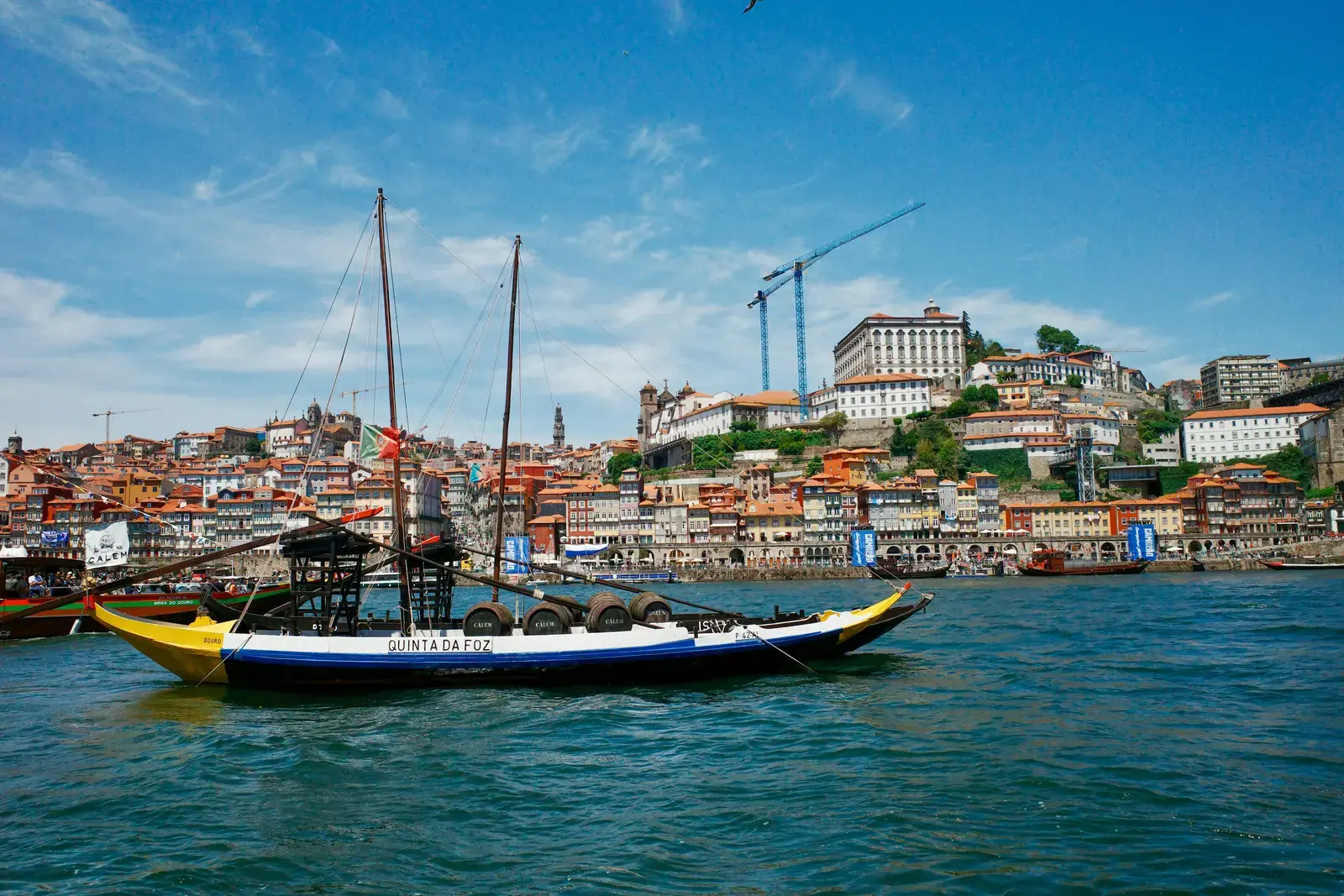 A traditional rabelo boat crossing the Douro in Porto.